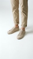 Stylish beige sneakers and rolled chinos on white background, minimalist casual footwear and pants combination for modern fashion and lifestyle concepts.