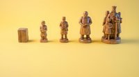 Hand-carved wooden figurines arranged by size on a yellow background, showcasing traditional folk art craftsmanship and artisan woodworking skills.