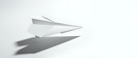 White paper airplane on clean background casting shadow, minimalist origami craft concept for business success and travel dreams.