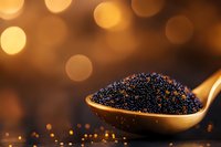 Black caviar in golden spoon with warm bokeh lights background for luxury dining and gourmet food concepts.
