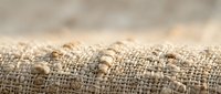 Natural burlap fabric texture with loose threads and frayed edges, rustic jute material for crafting and packaging applications.