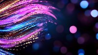 Magical glowing waves with sparkles in pink and blue colors against dark background, flowing light trails with bokeh effect create dreamy atmosphere.