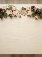 Wooden star ornaments, pine cones, evergreen branches, and red berries arranged on light wood surface with twine and gift tag for holiday greeting cards and seasonal marketing materials.