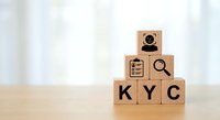 Wooden blocks spelling KYC with compliance icons including magnifying glass and user verification symbols for financial regulatory concepts.