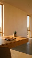 Minimalist wooden desk with notebook and small plant in modern home office with warm natural lighting from large windows creating peaceful workspace atmosphere.