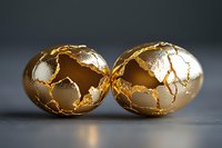 Cracked golden eggs with luxurious metallic texture and glowing cracks on dark background create dramatic lighting effect for luxury Easter concept.
