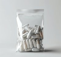 White pharmaceutical capsules in clear plastic zip bag against neutral background, medical supplement packaging concept for healthcare and pharmacy industry.