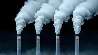 Industrial smokestacks emitting thick white smoke against dark sky, representing environmental pollution and climate change concerns.