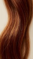 Glossy auburn hair strand with rich copper highlights, smooth silky texture, flowing wave pattern, close-up macro shot for beauty and haircare concepts.