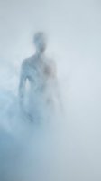 Ethereal figure emerging from soft blue and white mist, creating an atmospheric and dreamlike composition suitable for conceptual, spiritual, and editorial design projects.