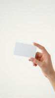 Female hand holding blank white business card mockup against neutral beige background for branding and corporate identity design projects.