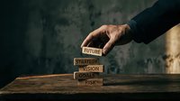 Business hand placing wooden blocks with future, strategy, vision, goal, risk words stacked on table for corporate planning and development concepts.