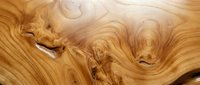 Wood grain texture with natural swirling patterns and knots, showcasing warm golden-brown tones. Suitable for backgrounds, design elements, and woodworking projects.