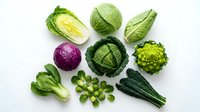 Fresh organic cabbage varieties and leafy greens arranged on white background for healthy cooking and nutrition concepts.