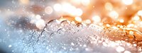 Water drops on metallic surface with soft bokeh lights creating abstract macro photography background in orange and blue tones with morning dew.
