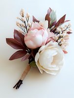 Delicate wedding boutonniere with pink and white peonies, burgundy leaves, and small cream blossoms wrapped in twine on white background for groom or groomsmen.