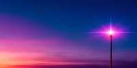 Street lamp glowing against dramatic sunset sky with vibrant pink and purple gradient colors merging into deep blue, creating atmospheric dusk scenery.