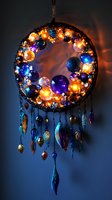 Mystical glowing dreamcatcher with illuminated glass orbs in blue, purple, and amber colors, decorated with hanging crystal pendants against dark background.