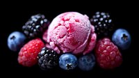Fresh berry ice cream scoop surrounded by ripe blueberries, blackberries and raspberries on dark background with dramatic lighting and selective focus.