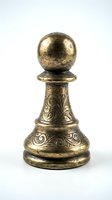 Antique brass chess pawn with ornate engraved details and weathered patina, isolated on white background for game strategy and collectible design projects.