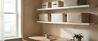 Modern minimalist home office workspace with floating white shelves, cardboard storage boxes, wooden desk and natural lighting for productivity and organization.