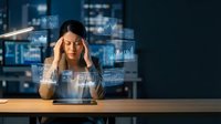 Stressed businesswoman with headache surrounded by holographic data charts and graphs in modern office environment for corporate burnout concepts.
