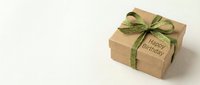 Kraft paper gift box with green ribbon bow and Happy Birthday tag on white background, perfect for holiday greeting and celebration concepts.