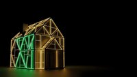 Golden house frame construction with green energy efficiency rating display on dark background for sustainable building concepts.