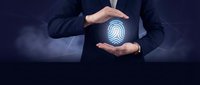 Businessman protecting digital fingerprint icon with hands representing cybersecurity, data protection and biometric authentication technology solutions.