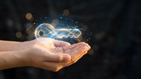 Glowing infinity symbol with light particles floating above open palm against dark background, representing endless possibilities and digital innovation.