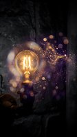 Vintage Edison bulb glowing with warm light and magical bokeh particles against dark textured wall creating atmospheric mood for creative projects.