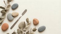 Zen spa composition with smooth river stones and eucalyptus branches on neutral background for wellness and relaxation concepts.