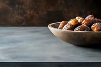 Fresh organic medjool dates in wooden bowl on dark background with copy space. Natural sweet dried fruits for healthy snacking and cooking.