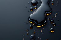Dark liquid spill with glowing golden edges and scattered droplets on black surface creates dramatic contrast and mysterious atmosphere for luxury design projects.