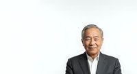 Senior Asian male executive in dark business suit and white shirt, isolated on white background for corporate headshots, professional portraits, and business website use.