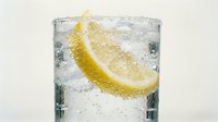 Refreshing sparkling water with fresh lemon slice and ice cubes, perfect for beverage, food and drink, wellness and hydration design projects.
