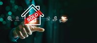 Businessman hand touching house icon with sold sign and real estate symbols on dark background with bokeh lights for property sales concept.