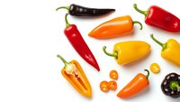 Colorful hot chili peppers collection isolated on white background. Fresh spicy vegetables in red, yellow, orange colors for cooking and seasoning.