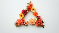 Vibrant floral triangle arrangement with roses, dahlias, and mixed blooms in warm orange, red, and peach tones against white background.