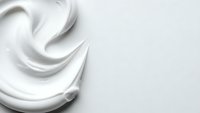 Smooth white cream swirl texture with flowing curves on clean background for skincare and cosmetic product design applications.