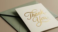 Elegant thank you card with gold foil calligraphy lettering beside a sage green envelope on a neutral background for greeting design.