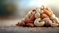 Mixed raw nuts including cashews and almonds on rustic wooden surface with soft natural lighting and shallow depth of field, highlighting texture and detail.
