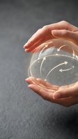 Hands holding transparent sphere with glowing arrows indicating circular flow, representing business strategy, continuous improvement, and sustainable growth concepts.