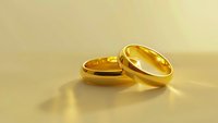 Pair of shiny golden wedding bands on neutral surface, symbolizing commitment and marriage. Suitable for wedding invitations, jewelry websites, and engagement announcements.