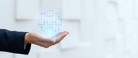 Businessman hand presenting glowing digital healthcare cross symbol in modern medical office environment for technology and wellness concepts.