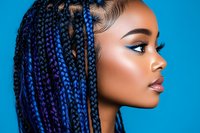 Young African American woman with blue braids and flawless makeup in profile view against vibrant blue background, showcasing modern beauty and natural glamour.
