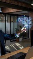 Person in dark business attire interacting with glowing neon envelope icons floating above wooden desk in modern office with exposed brick and glass partitions.