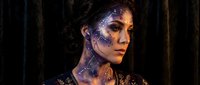Young woman with futuristic cyberpunk makeup featuring metallic blue and purple face paint in sci-fi style for fantasy cosplay and creative portrait photography.