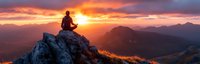 Silhouette of person meditating on mountain peak at dramatic sunset, panoramic view of misty mountains with orange and purple sky, peaceful mindfulness moment.