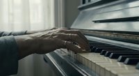 Elderly hands playing piano keys in soft natural light, showcasing musical passion and artistic expression in cozy home setting.